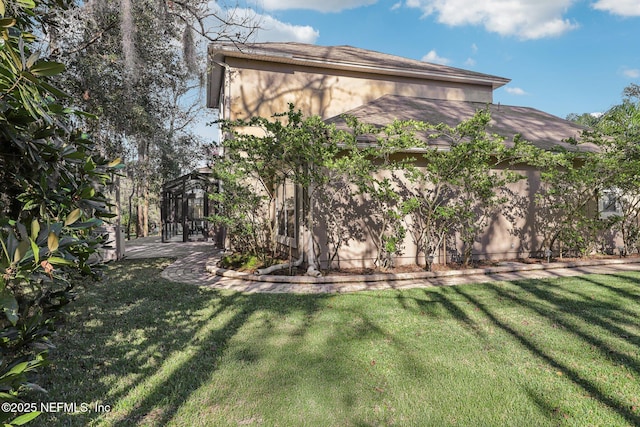 view of property exterior featuring a yard, a patio area, and stucco siding