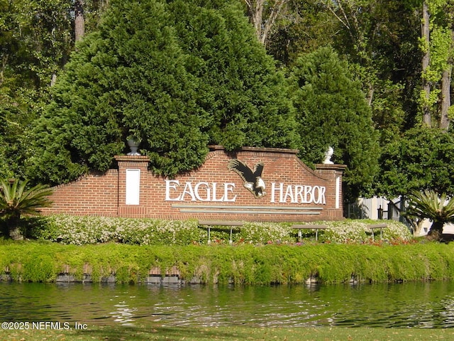 community / neighborhood sign featuring a water view