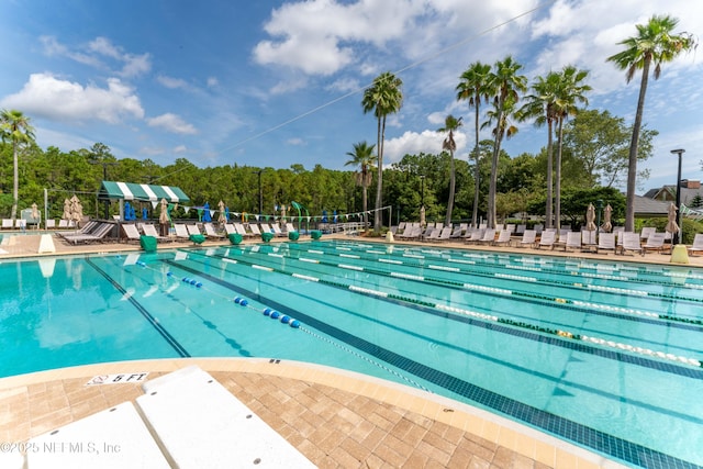 community pool with a patio area and fence