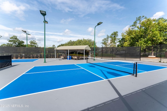 view of tennis court featuring fence