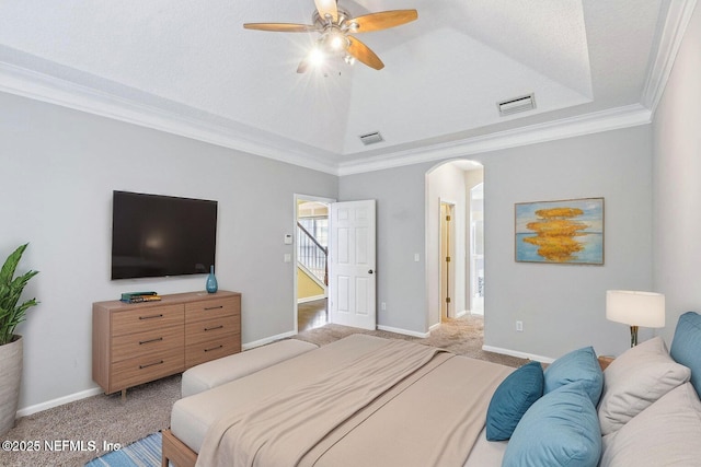 bedroom with visible vents, arched walkways, a raised ceiling, light colored carpet, and ornamental molding