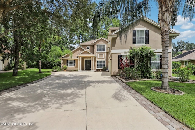 1494 Walnut Creek Dr, Fleming Island, FL 32003 - traditional home with stucco siding, concrete driveway, and a front yard