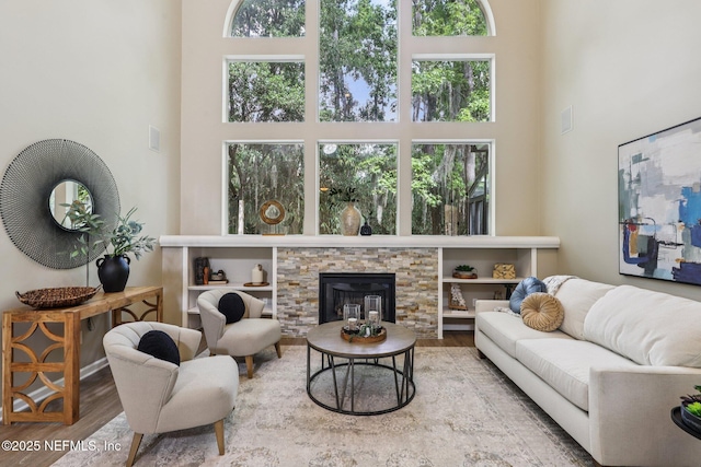 1494 Walnut Creek Dr, Fleming Island, FL 32003 - living area with a high ceiling, wood finished floors, healthy amount of natural light, and a stone fireplace