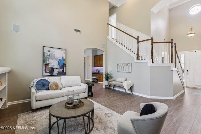 1494 Walnut Creek Dr, Fleming Island, FL 32003 - living area with arched walkways, a high ceiling, wood finished floors, and stairway