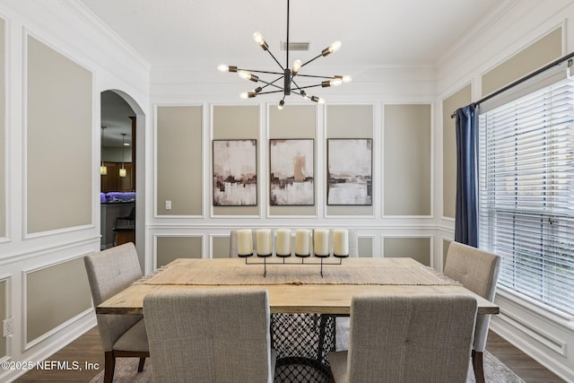 1494 Walnut Creek Dr, Fleming Island, FL 32003 - dining area featuring a decorative wall, a chandelier, arched walkways, plenty of natural light, and dark wood-style flooring