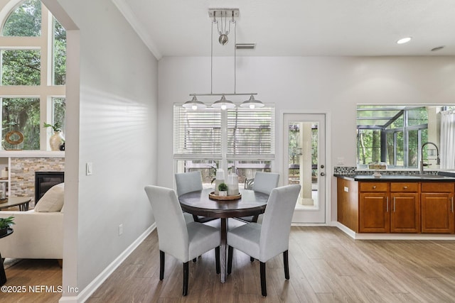 1494 Walnut Creek Dr, Fleming Island, FL 32003 - dining area with light wood-style flooring, a fireplace, and recessed lighting