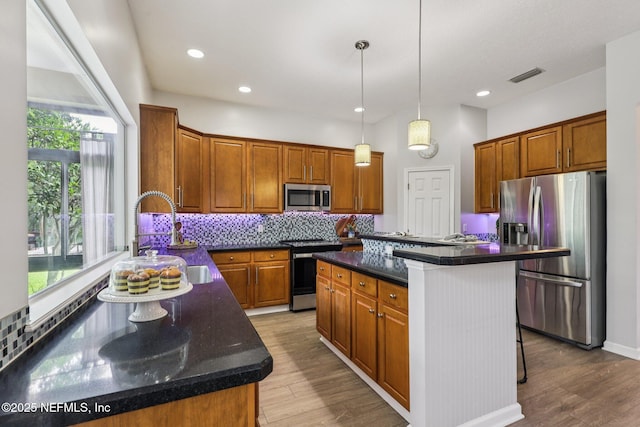 1494 Walnut Creek Dr, Fleming Island, FL 32003 - kitchen featuring appliances with stainless steel finishes, a kitchen island, backsplash, wood finished floors, and recessed lighting