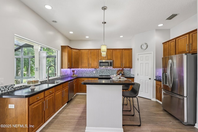 1494 Walnut Creek Dr, Fleming Island, FL 32003 - kitchen featuring stainless steel appliances, decorative backsplash, dark countertops, brown cabinetry, and recessed lighting