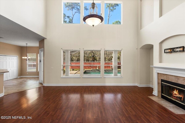 unfurnished living room with a healthy amount of sunlight, a fireplace, and an inviting chandelier