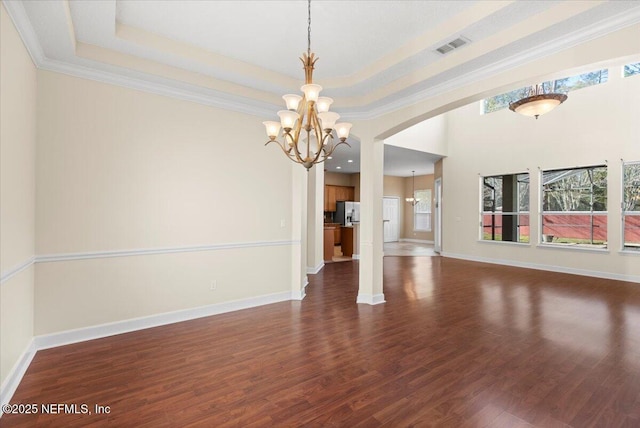 interior space with an inviting chandelier, baseboards, dark wood-style floors, and a tray ceiling