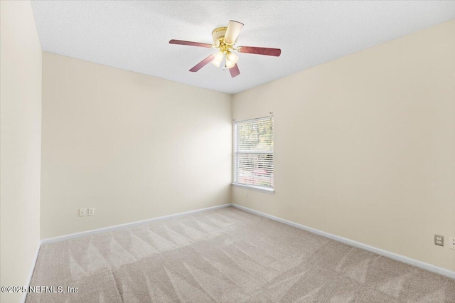 spare room featuring carpet floors, a ceiling fan, baseboards, and a textured ceiling