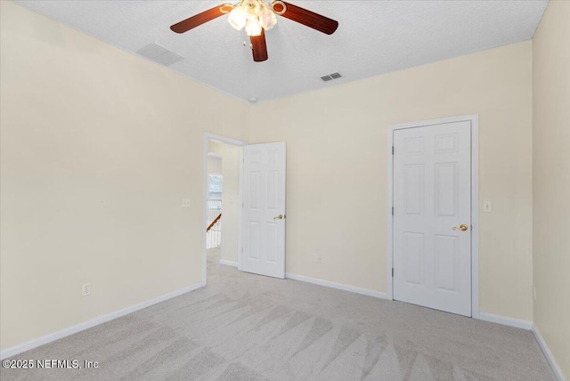 unfurnished bedroom with baseboards, carpet, visible vents, and a textured ceiling