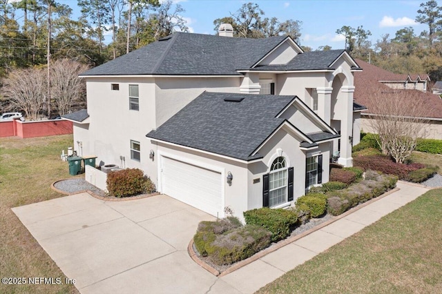 view of front facade featuring roof with shingles, a chimney, stucco siding, an attached garage, and a front yard