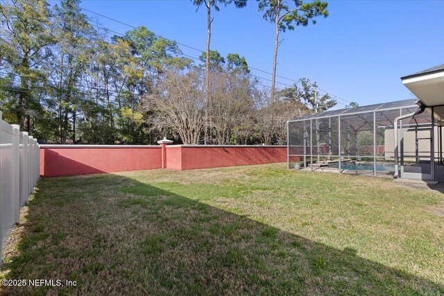 view of yard featuring glass enclosure, a fenced backyard, and an outdoor pool