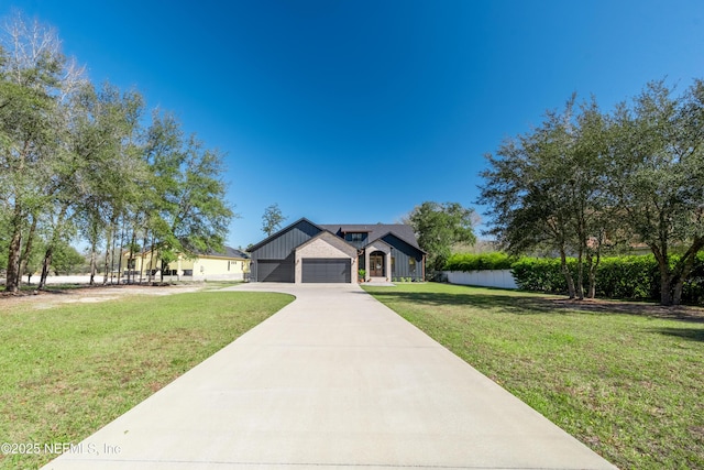 view of front of property with driveway, board and batten siding, and a front yard