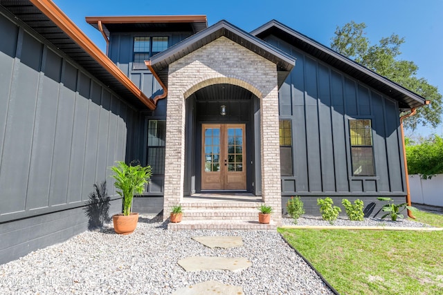 property entrance with brick siding, board and batten siding, and french doors