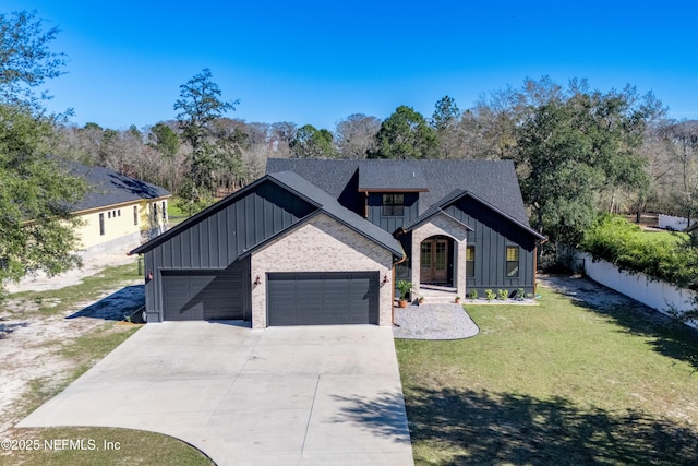 modern farmhouse style home featuring a garage, driveway, a balcony, a front lawn, and board and batten siding