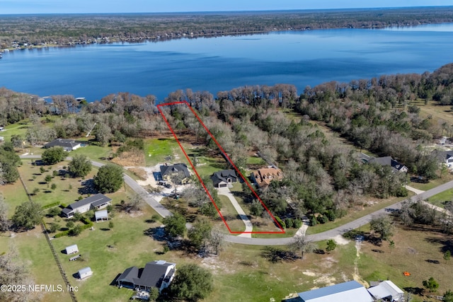 aerial view with a water view and a wooded view