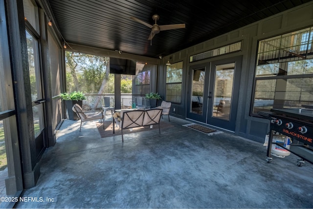 unfurnished sunroom featuring ceiling fan