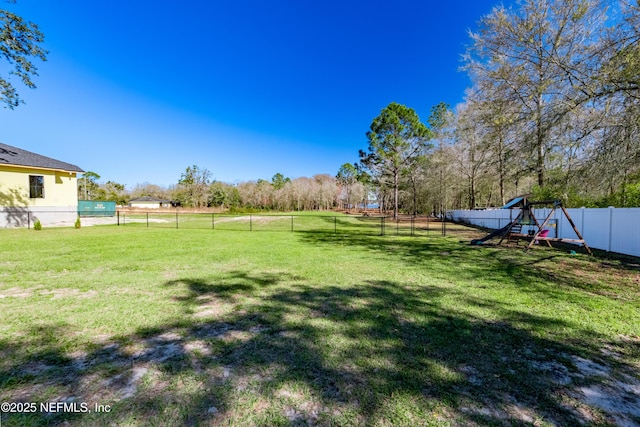 view of yard featuring a fenced backyard and a playground