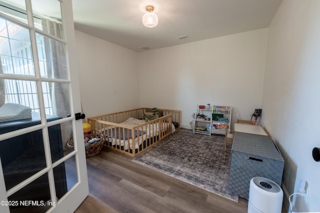 bedroom featuring wood finished floors and visible vents