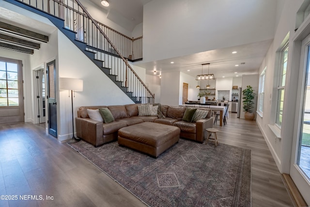 living room with baseboards, a towering ceiling, stairway, dark wood-type flooring, and recessed lighting