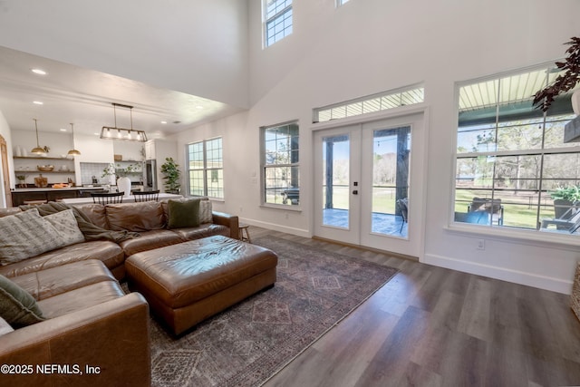 living room with baseboards, dark wood-style flooring, a high ceiling, french doors, and recessed lighting