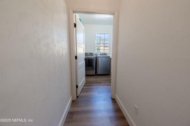 corridor with wood finished floors, washing machine and clothes dryer, and baseboards