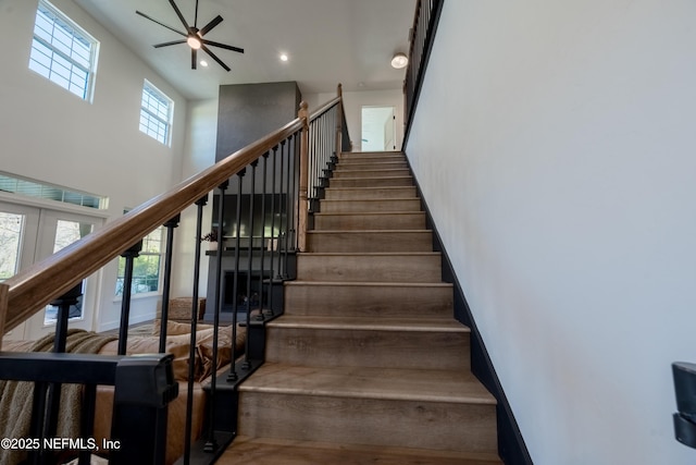 stairs with recessed lighting, a high ceiling, baseboards, and french doors