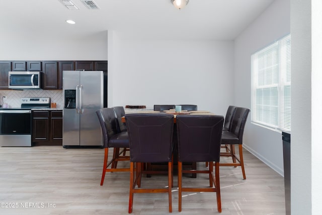 dining room with baseboards and light wood finished floors