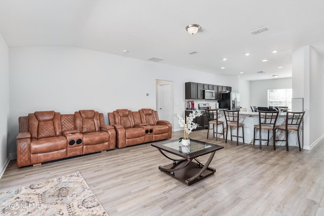 living area featuring recessed lighting, visible vents, light wood-style flooring, and baseboards