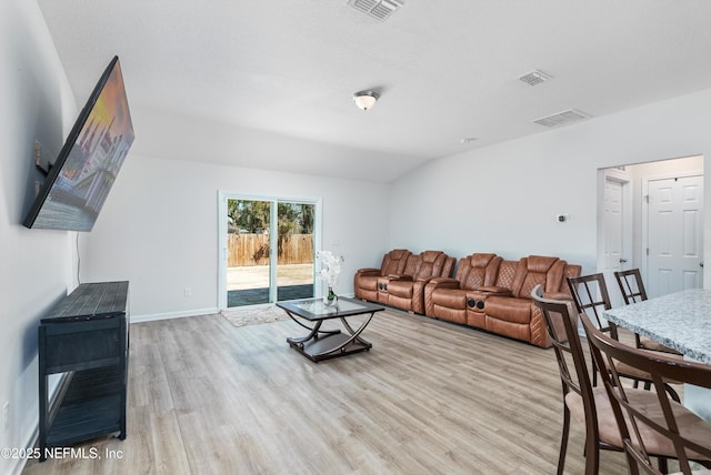 living area featuring baseboards, visible vents, vaulted ceiling, and wood finished floors