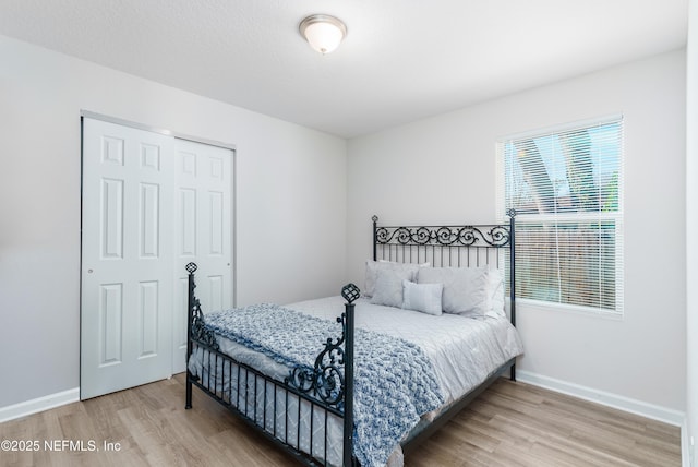 bedroom featuring a closet, baseboards, and wood finished floors