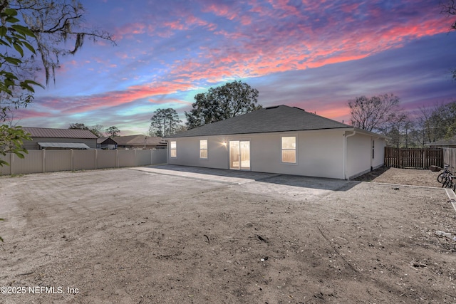 rear view of house with a fenced backyard and stucco siding