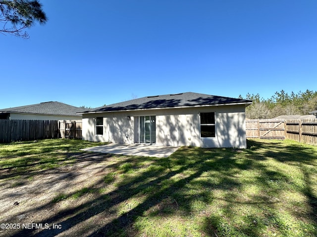 back of house featuring a patio, a yard, and a fenced backyard