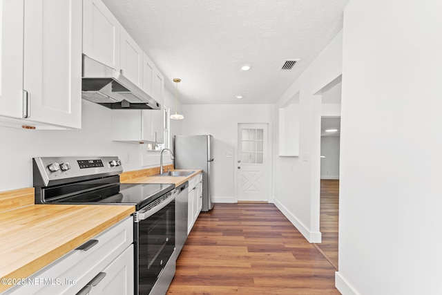 kitchen featuring visible vents, white cabinets, appliances with stainless steel finishes, under cabinet range hood, and a sink