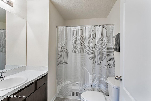 full bathroom featuring toilet, a shower with shower curtain, a textured ceiling, and vanity