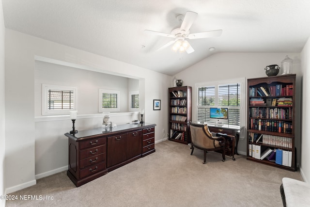 home office with lofted ceiling, ceiling fan, light carpet, and baseboards