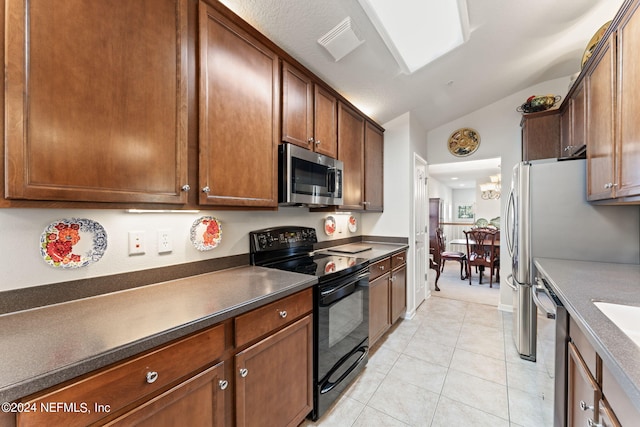 kitchen with dark countertops, visible vents, appliances with stainless steel finishes, light tile patterned flooring, and vaulted ceiling