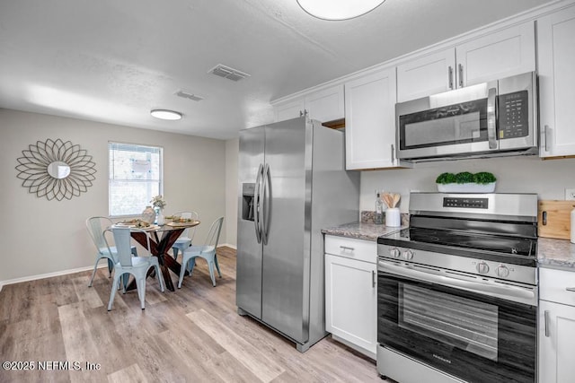 kitchen featuring white cabinets, light wood-type flooring, visible vents, and stainless steel appliances