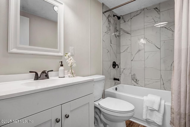 bathroom featuring vanity, wood finished floors, shower / bath combination with curtain, a textured ceiling, and toilet