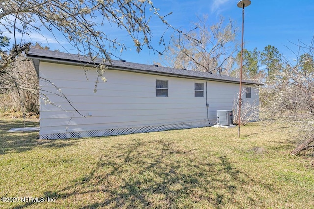 rear view of house with a lawn and central AC