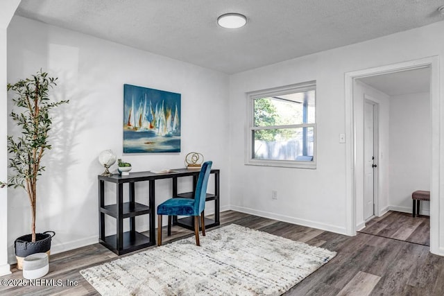 office featuring dark wood-style floors, baseboards, and a textured ceiling