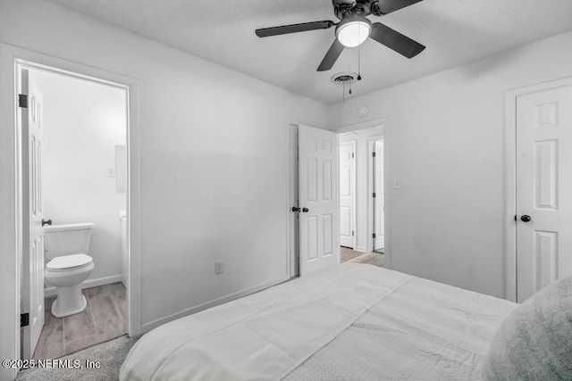 bedroom featuring ensuite bathroom, a ceiling fan, baseboards, visible vents, and light wood-style floors