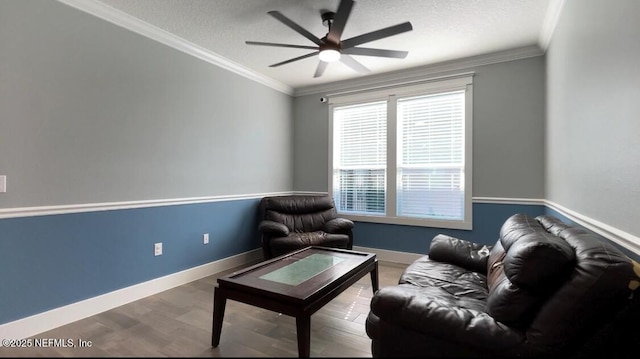 living area featuring crown molding, a textured ceiling, baseboards, and wood finished floors