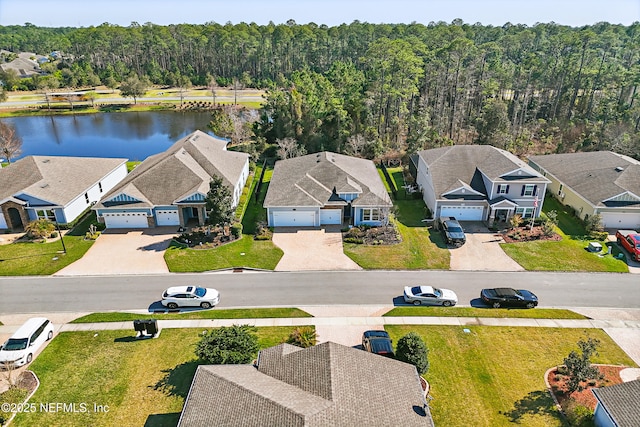 aerial view with a water view, a wooded view, and a residential view