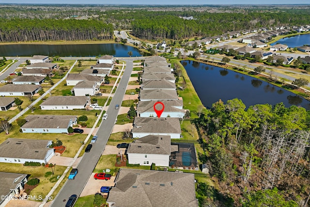 birds eye view of property featuring a water view, a forest view, and a residential view