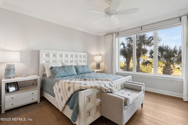 bedroom featuring ornamental molding, a ceiling fan, baseboards, and wood finished floors