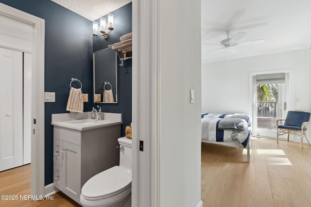 bathroom featuring a ceiling fan, vanity, toilet, and wood finished floors