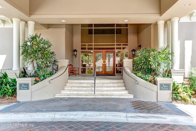 property entrance featuring stucco siding and french doors